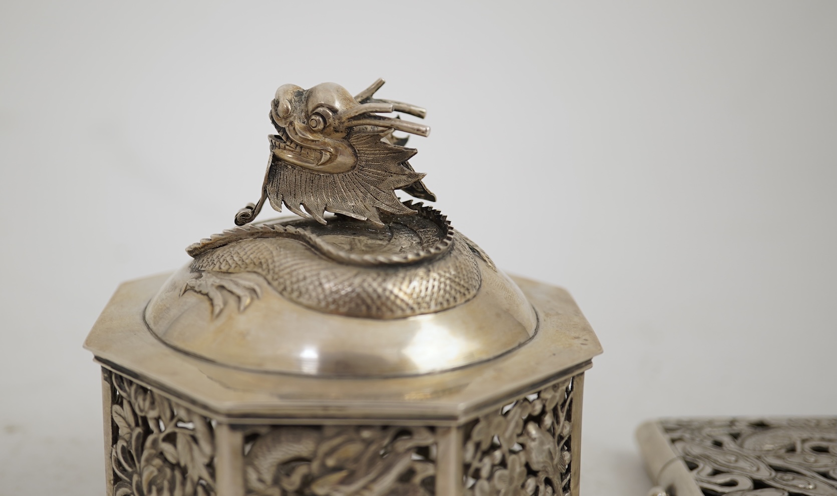 A late 19th century Chinese Export pierced silver card case, maker KMS(Kwong Man Shing), decorated with dragons amid clouds, 10.4cm, together with a Chinese Export pierced silver octagonal box and cover, by Luen Wo?, cir